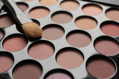 Photo of Beautiful eye shadow palette with brush, closeup