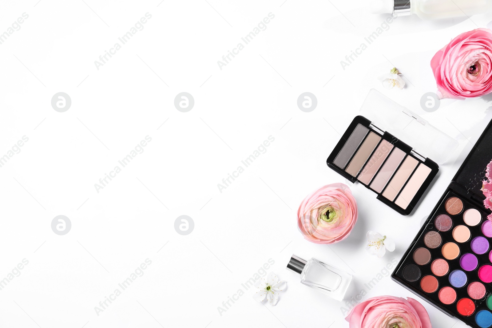 Photo of Flat lay composition with different makeup products and beautiful spring flowers on white background, space for text