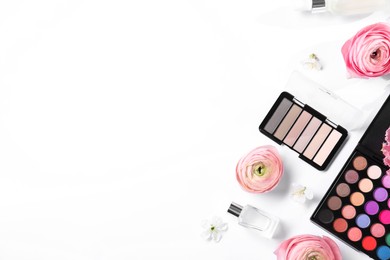 Flat lay composition with different makeup products and beautiful spring flowers on white background, space for text