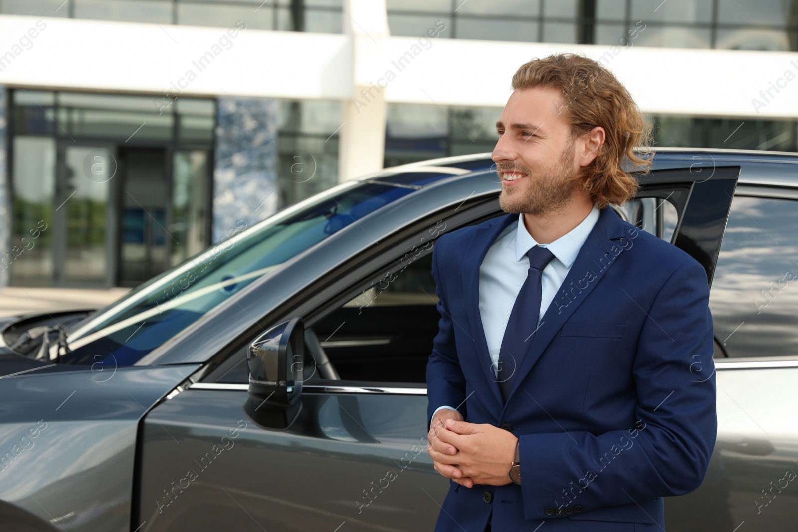 Photo of Attractive young man near luxury car outdoors