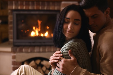 Lovely couple near fireplace at home. Winter vacation