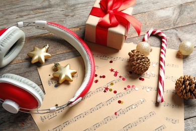 Photo of Composition with Christmas decorations, music sheets and headphones on wooden background