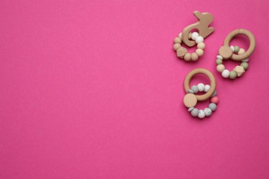 Photo of Cute wooden baby toys on bright pink background, flat lay. Space for text
