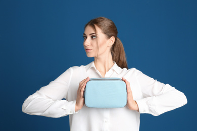 Photo of Beautiful young woman with stylish bag on blue background