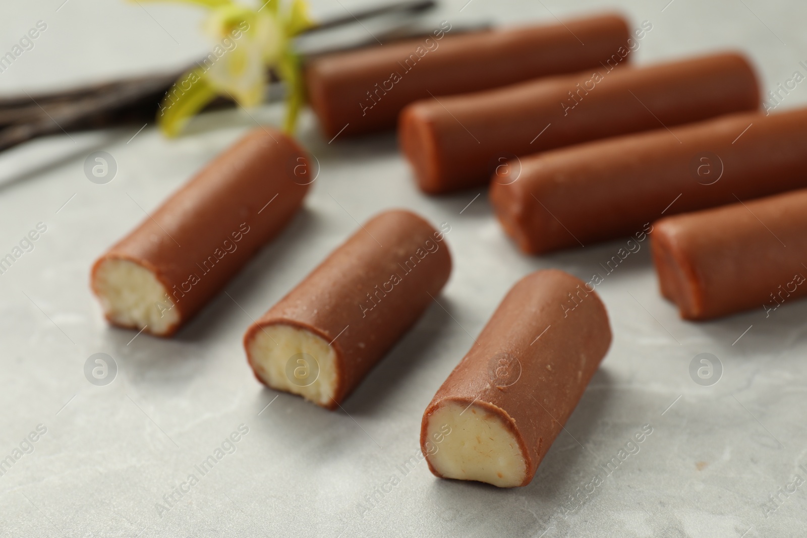 Photo of Glazed curd cheese bars on grey table, closeup