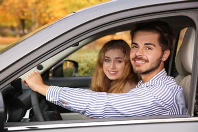 Young man sitting in car with passenger. Driving license test