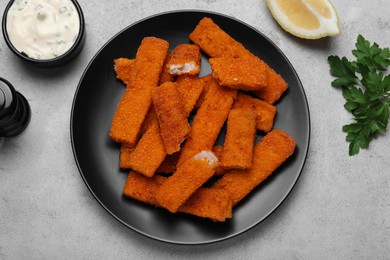 Photo of Fresh breaded fish fingers served on light grey table, flat lay