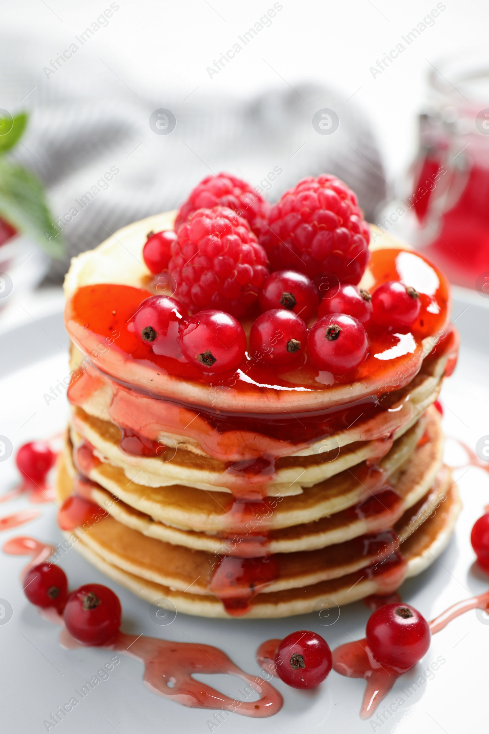 Photo of Delicious pancakes with fresh berries and syrup on plate