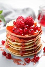 Photo of Delicious pancakes with fresh berries and syrup on plate