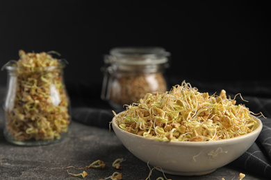 Bowl of sprouted green buckwheat on grey table