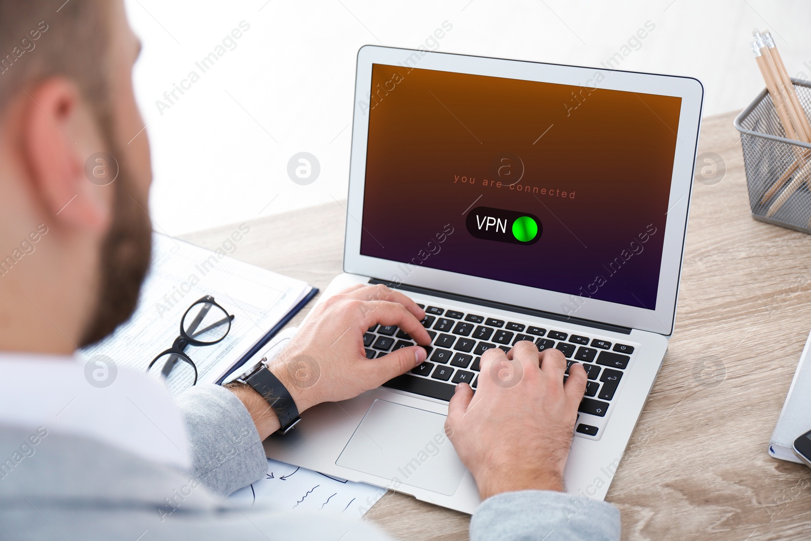 Image of Man using laptop with switched on VPN at table, closeup