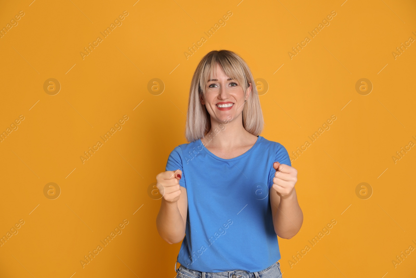 Photo of Happy woman pretending to drive car on yellow background