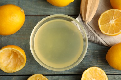 Freshly squeezed lemon juice on blue wooden table, flat lay