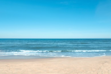 Photo of Blurred view of beautiful sea and sandy beach on sunny day