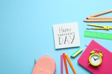 Flat lay composition of card with inscription HAPPY TEACHER'S DAY and stationery on light blue background, space for text