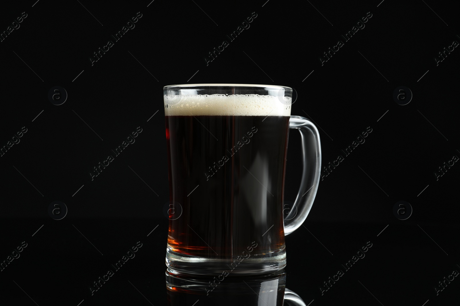 Photo of Glass mug of delicious kvass on black background