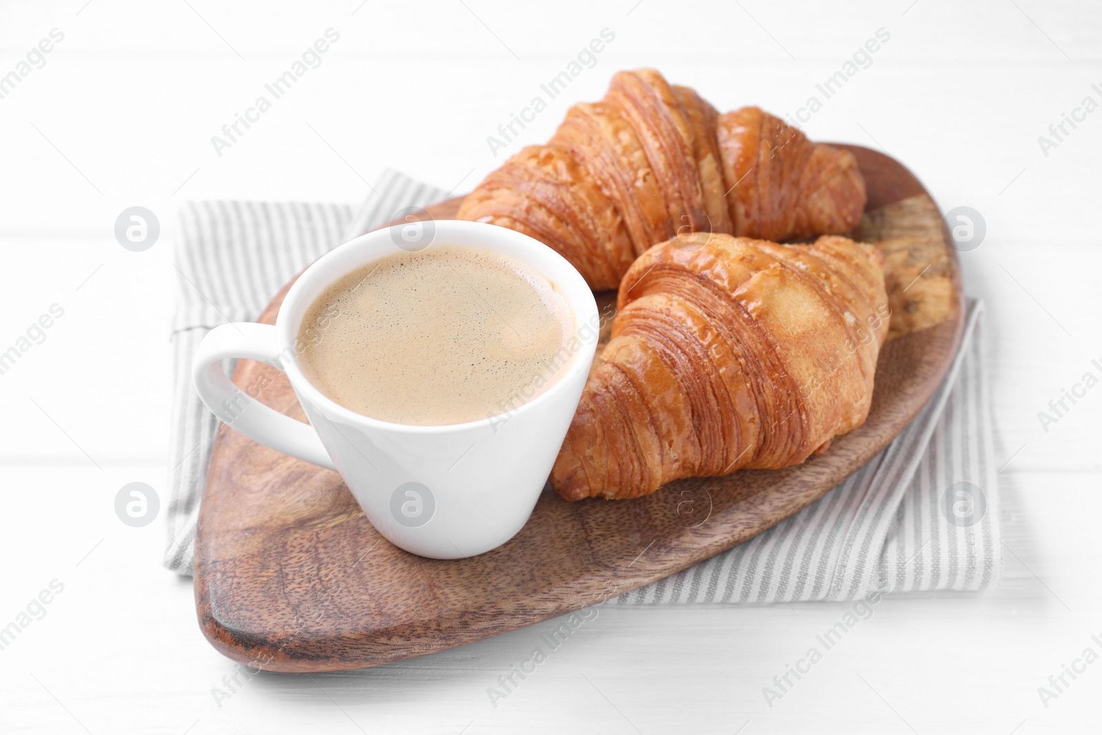 Photo of Tasty breakfast. Cup of coffee and croissants on white wooden table