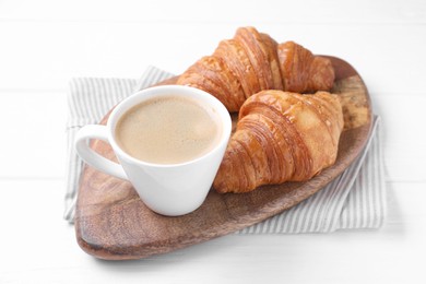 Photo of Tasty breakfast. Cup of coffee and croissants on white wooden table