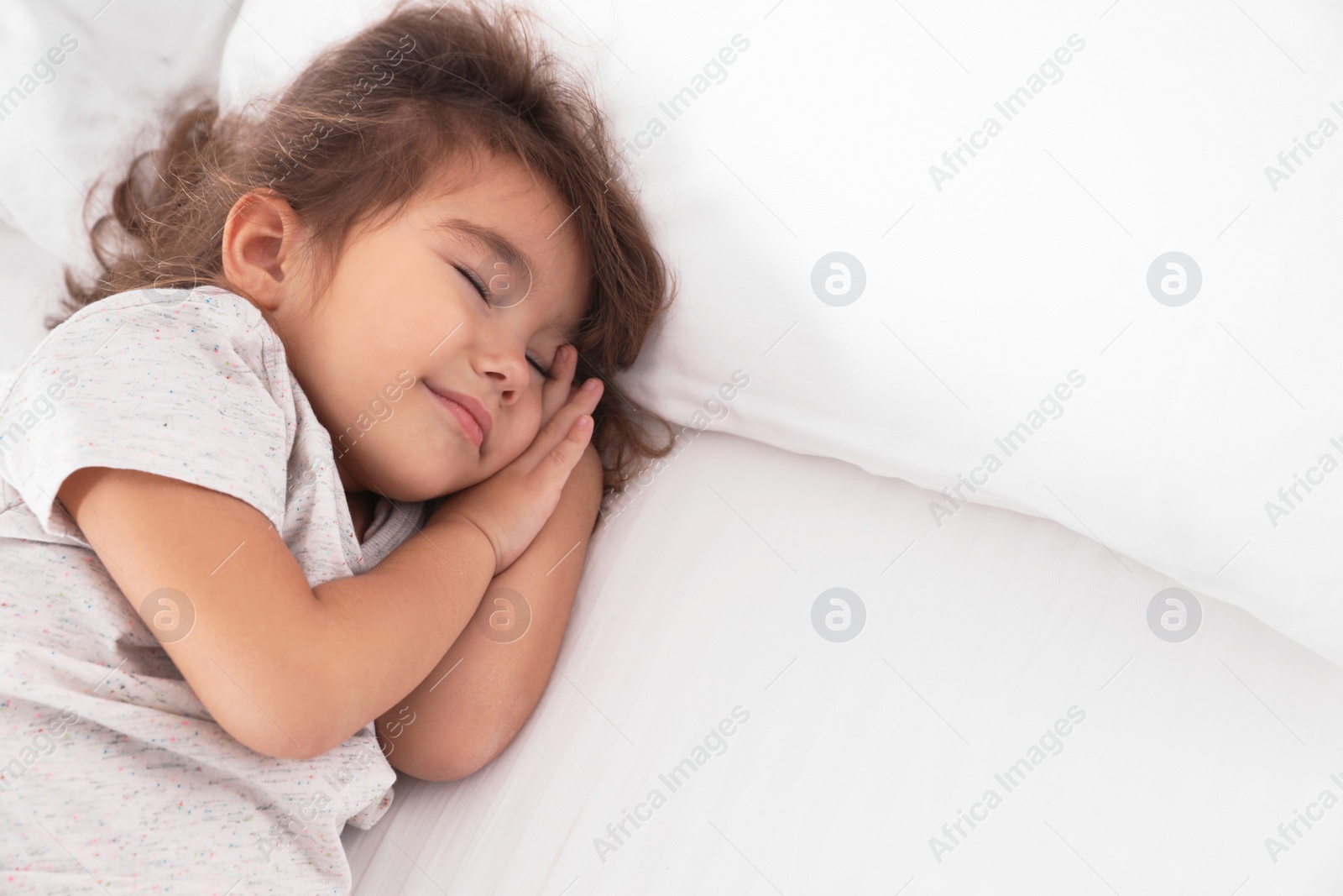 Photo of Cute little girl sleeping on bed. Space for text