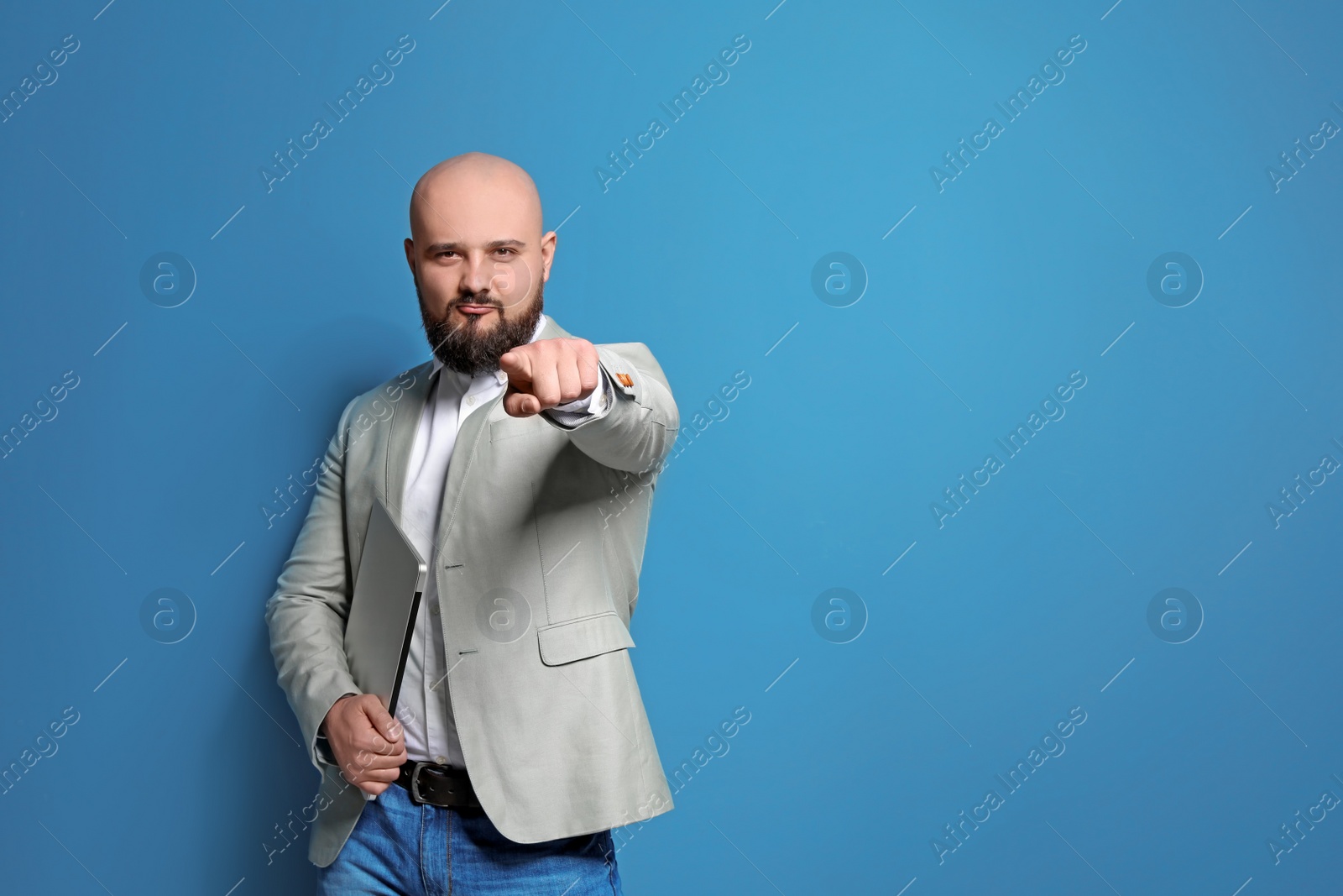 Photo of Portrait of confident young businessman with laptop on color background