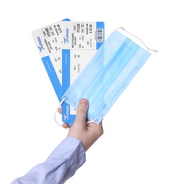 Photo of Woman holding tickets and protective mask on white background, closeup. Travel during quarantine