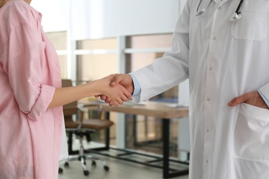 Photo of Doctor and patient shaking hands in clinic, closeup