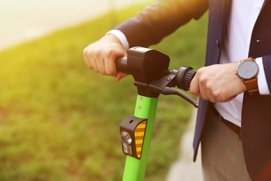 Photo of Businessman with modern kick scooter outdoors, closeup. Space for text