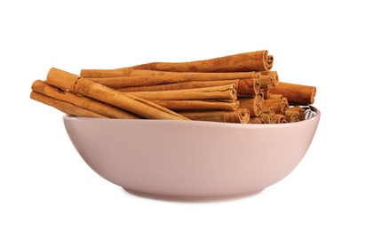 Aromatic dry cinnamon sticks in bowl on white background