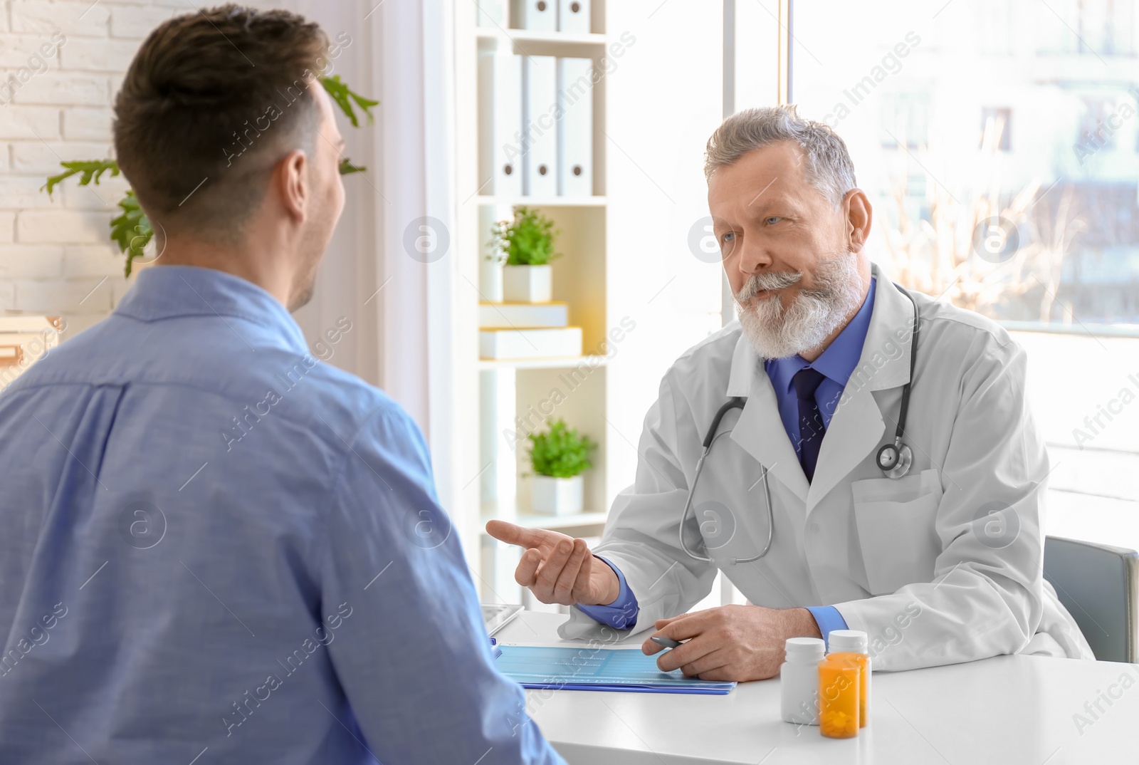 Photo of Mature doctor consulting patient in clinic