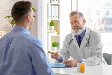 Photo of Mature doctor consulting patient in clinic