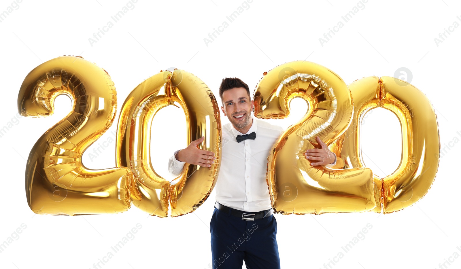 Photo of Happy young man with golden 2020 balloons on white background. New Year celebration