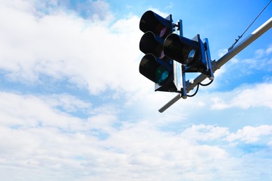 Photo of Traffic light against cloudy sky in city. Space for text