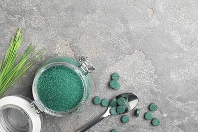 Photo of Flat lay composition with jar of spirulina powder and space for text on grey background