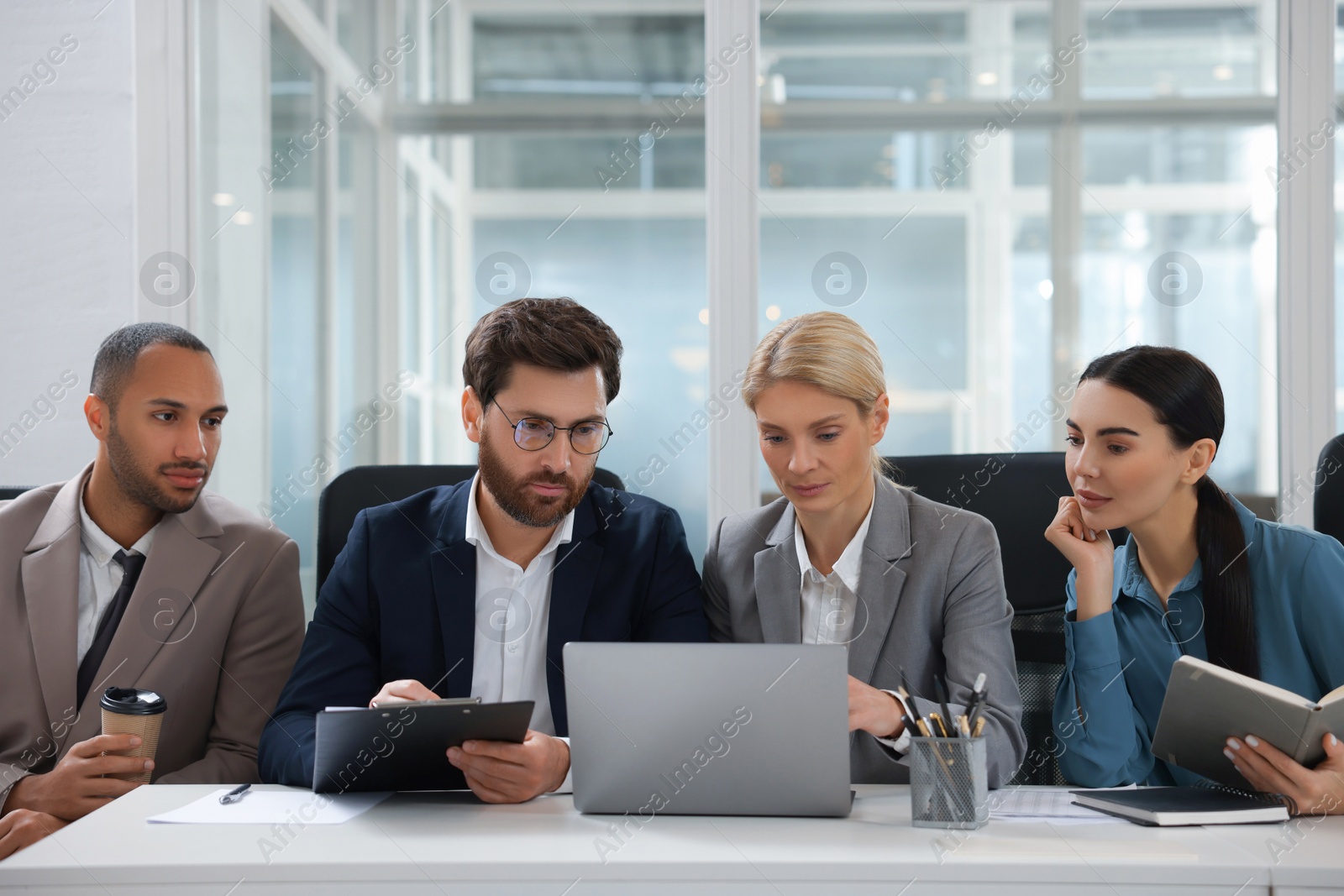 Photo of Lawyers working together with laptop at table in office