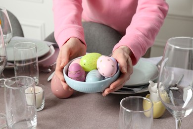 Photo of Woman setting table for festive Easter dinner at home, closeup