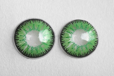 Photo of Two green contact lenses on white background, top view
