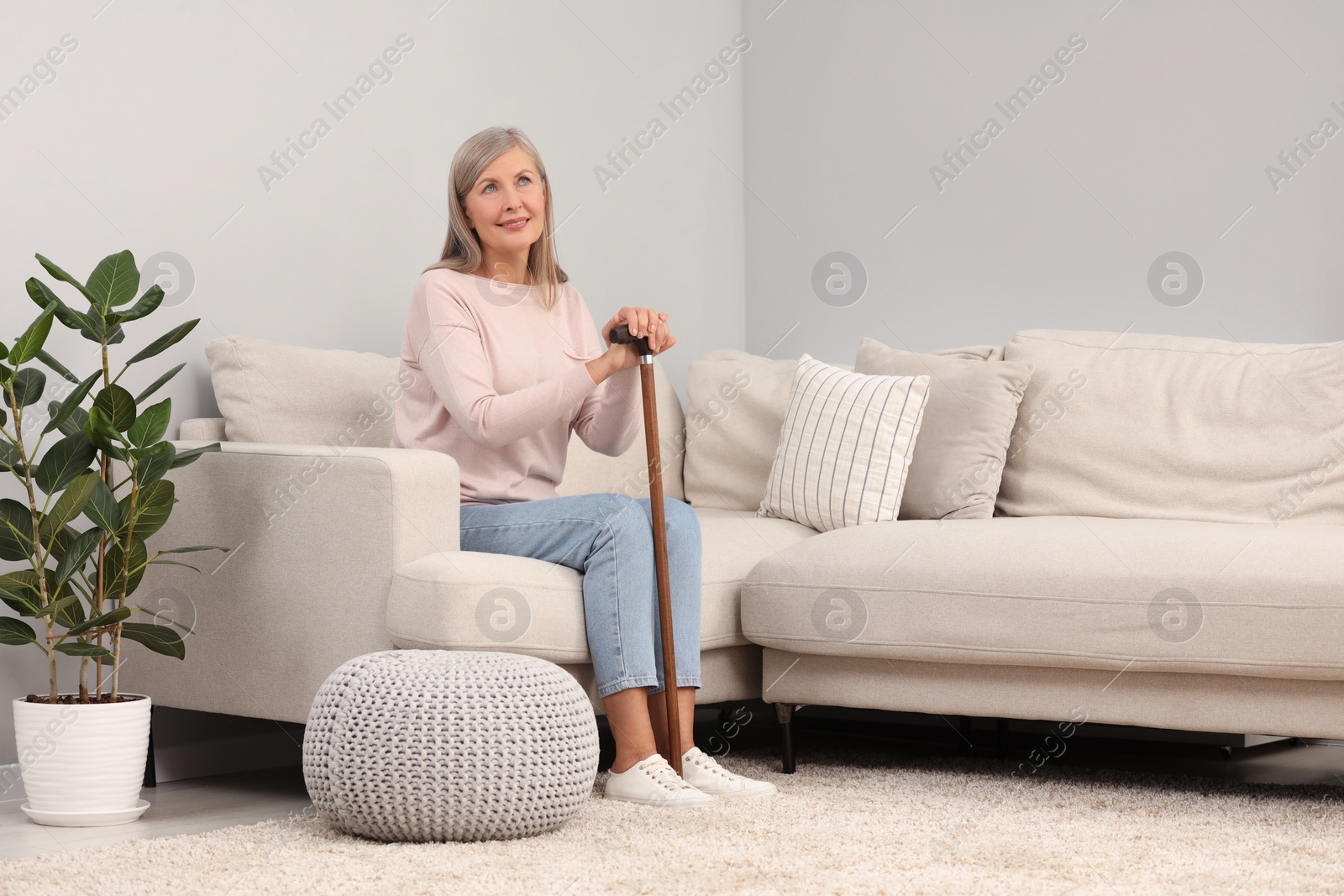 Photo of Mature woman with walking cane on sofa at home