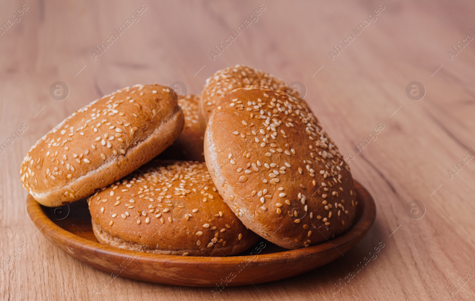 Photo of Fresh buns with sesame seeds on wooden table