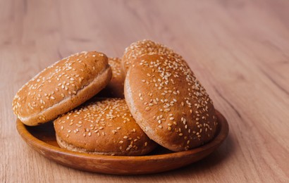 Photo of Fresh buns with sesame seeds on wooden table