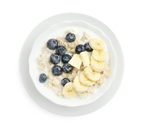 Photo of Tasty oatmeal with banana, blueberries, milk and butter in bowl isolated on white, top view