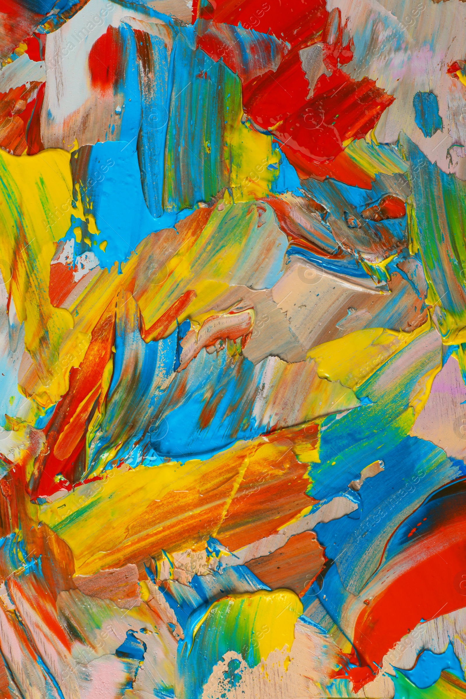 Photo of Closeup view of artist's palette with mixed bright paints as background