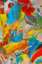 Closeup view of artist's palette with mixed bright paints as background