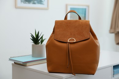 Stylish urban backpack on white table in room