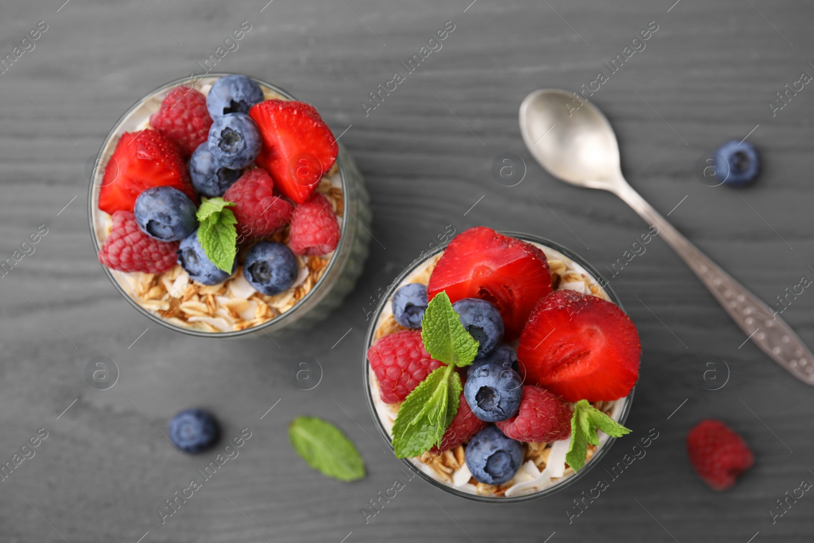 Photo of Tasty oatmeal with smoothie, berries and mint on grey wooden table, flat lay. Healthy breakfast