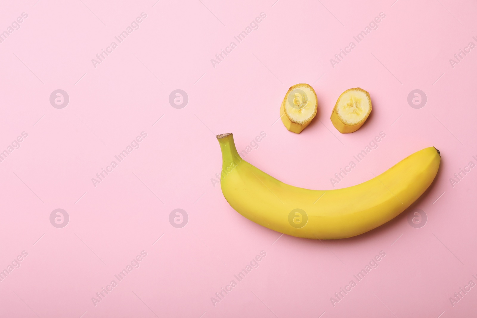 Photo of Funny flat lay composition with bananas on color background. Space for text