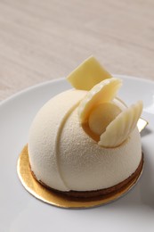 Photo of Delicious mousse cake with white chocolate on plate, closeup