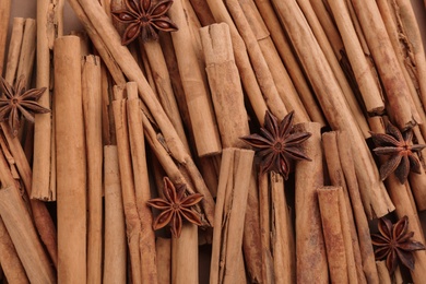 Aromatic cinnamon sticks and anise as background, top view