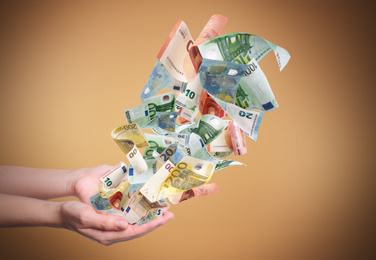 Woman with money on light brown background, closeup. Currency exchange