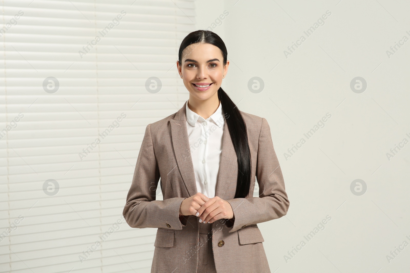 Photo of Beautiful real estate agent in nice suit indoors