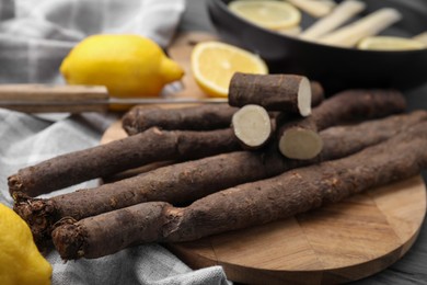 Photo of Raw salsify roots with lemon on table